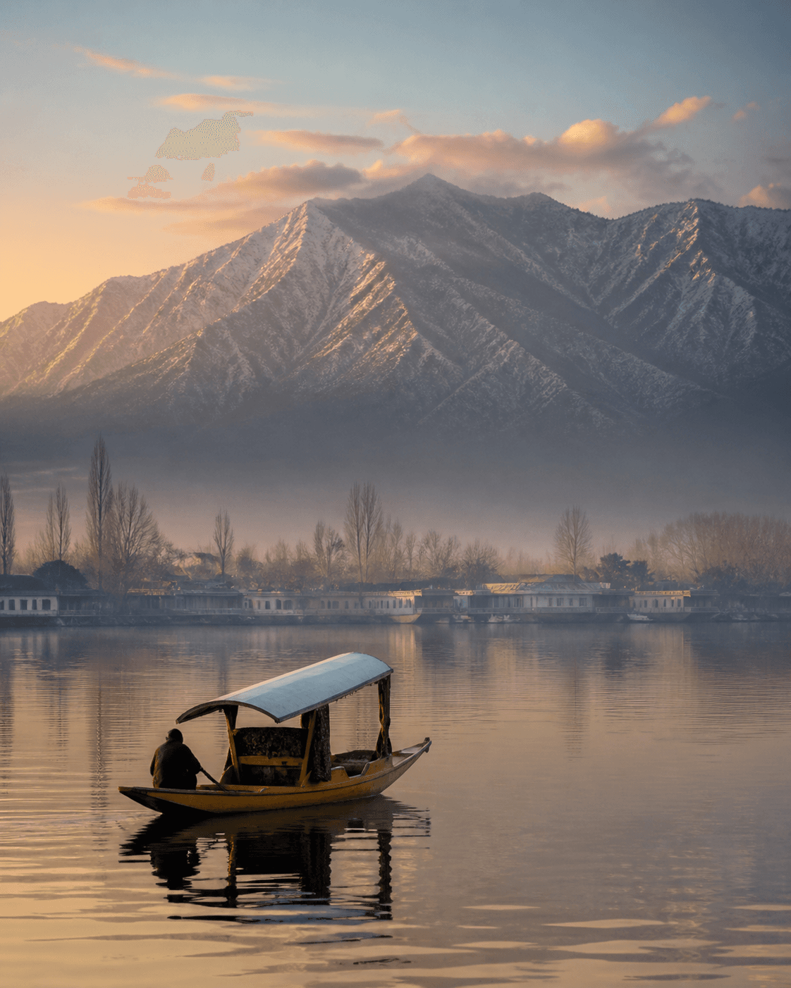 A shikara crossing Dal Lake at dawn